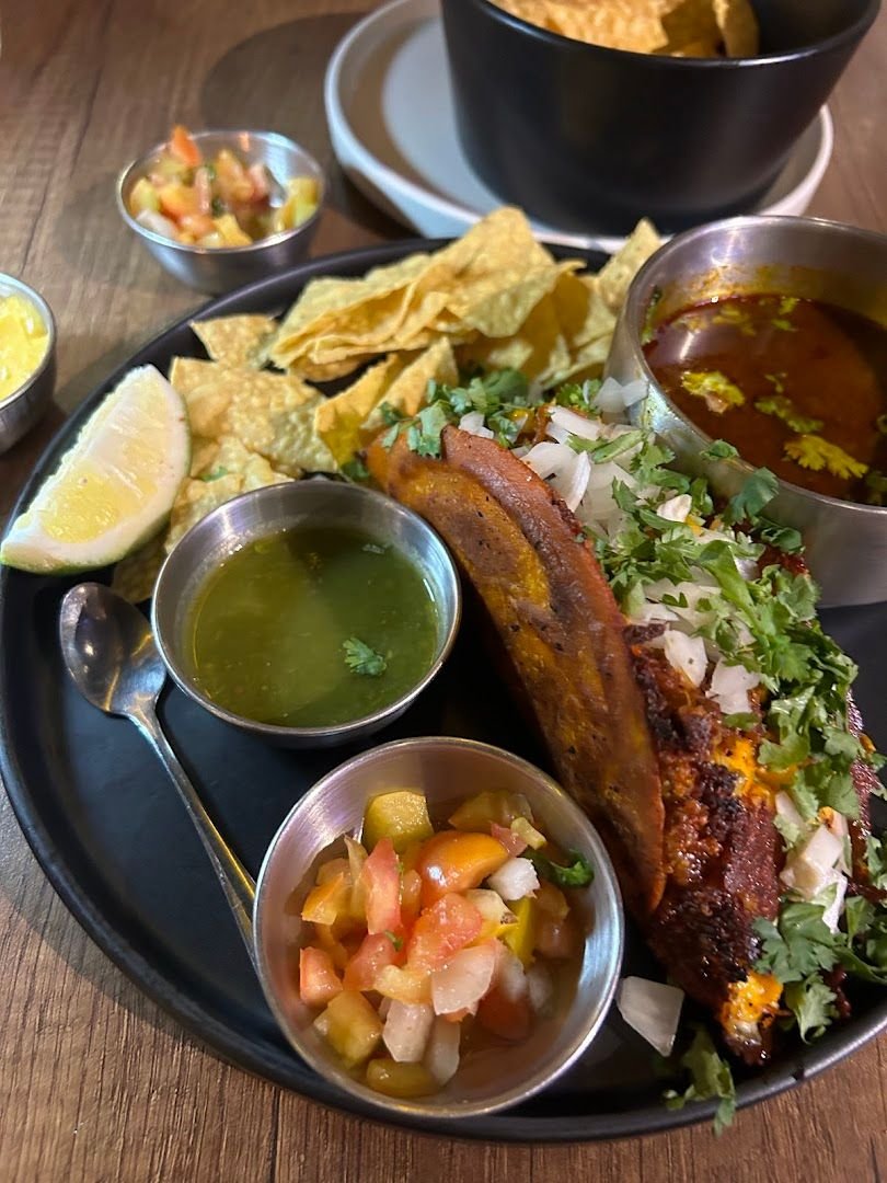 Molcajete platter with nachos, salsa, and smoked meat at La Guada Mas